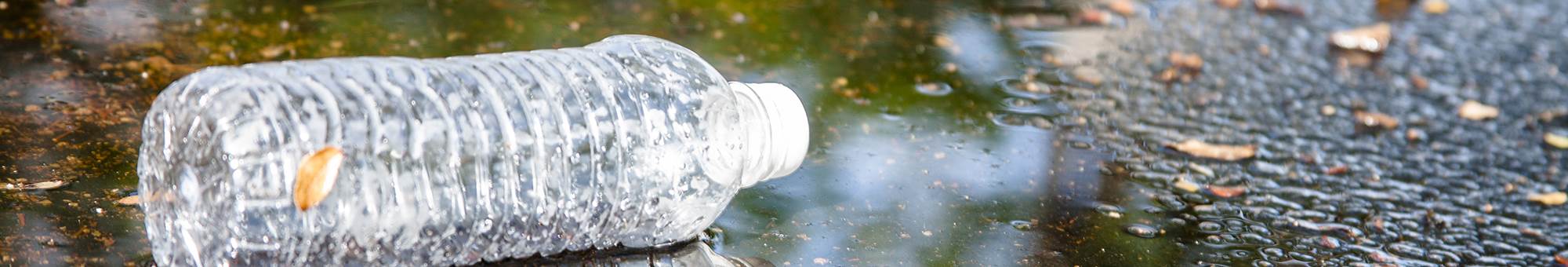 Plastic bottle in puddle